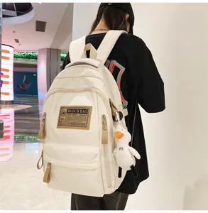 Trendy off-white khaki utility backpack with multi-compartments and cute duck pendant detail.