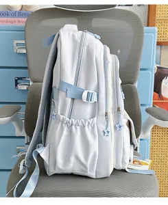 Vista dettagliata di un grazioso zaino per studenti azzurro con cursori della cerniera a stella.