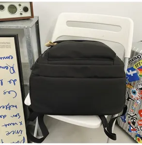 Detailed view of the casual black backpack featuring durable fabric and multiple compartments.