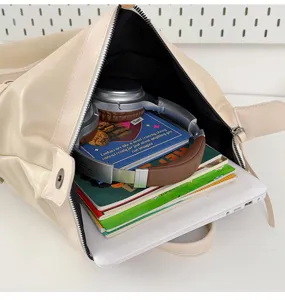 Beige leather backpack interior detail showing large capacity for laptop and books, stylish commute.