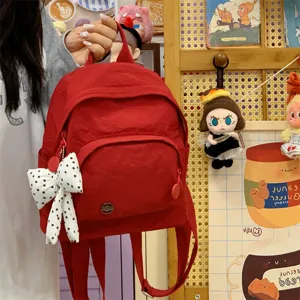 Red mini backpack for women, stylish minimalist casual small daypack with bow pendant.