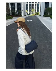 Casual denim schoudertas met geweven riem en meerdere vakken voor dagelijks gebruik.