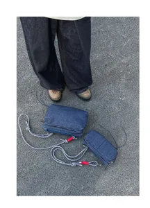 Gedetailleerd overzicht van casual denim crossbody tas met gevlochten riem en meerdere vakken.