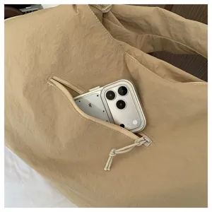Close-up detail of the pleated shoulder bag zipper pocket with phone minimalist design