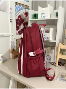 Red casual school backpack with white side panels and adjustable buckle straps for students.