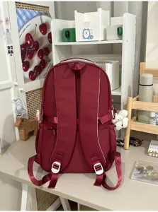 Detailed view of the burgundy student backpack, showing sturdy straps and functional pockets.