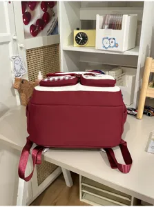 Detail view of the sweet college-style student backpack in maroon and white, in a tidy study setting.