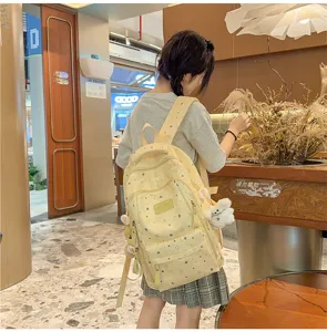 Yellow star print canvas school backpack with multiple compartments for daily casual travel use.