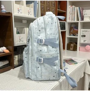Side detail view of light blue star print school backpack with adjustable straps and pockets.