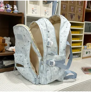 Detail view of the light blue star print multi-compartment school backpack interior.