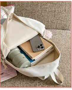 Vue détaillée de la capacité intérieure du sac à dos en toile blanche avec des cahiers.