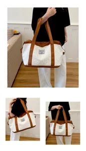 Détail de ce sac de voyage en toile au motif d'étoiles avec de solides poignées marron.