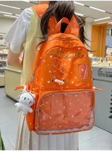 Orange star ita backpack detail showing clear window pocket, cute plush pendant and cross lacing.