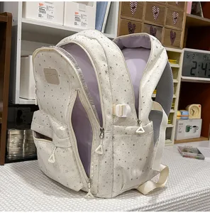 Detailansicht des Sternenmuster-Rucksacks mit mehreren Fächern, Seitentaschen und Reißverschlüssen.