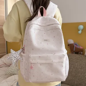 Detail view of the pink and white star print Japanese style backpack with a cute star charm.