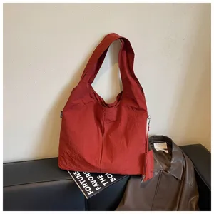 Dettaglio di una borsa tote marrone vintage, presentata con stile su sfondo casual.