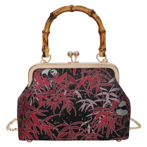 Closeup of retro Chinese style kiss lock bag detail featuring bamboo handle and panda pattern.