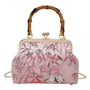 Close-up detail of the retro pink kiss-lock bag featuring delicate bamboo and cute panda patterns.