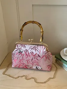 Vintage Chinese style kiss lock handbag with bamboo handle and panda brocade pattern.