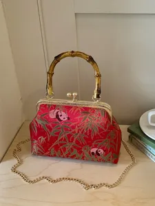 Chinese style retro kiss-lock shoulder bag with panda embroidery and elegant bamboo handle.