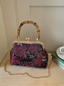 Vintage Chinese style kiss lock handbag with bamboo handle and red bamboo leaf print design.