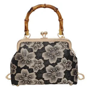 Vintage black embroidered cherry blossom kiss-lock handbag with bamboo handle and chain.