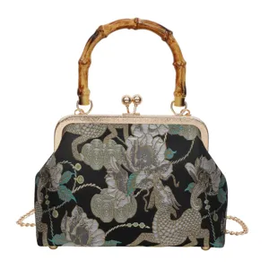 Detailweergave van vintage brokaat avondtas met bamboe handvat en gouden metalen sluiting.