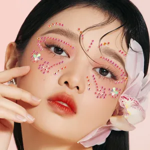 Close-up detail of festival face rhinestones makeup sparkle gems on woman eye corner skin decor.