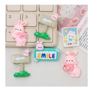 Close-up detail of cute pink bunny resin charms for DIY cream glue phone case craft accessories.
