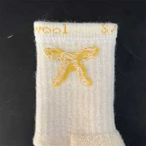 Merino wool mid-calf socks for women, thick thermal terry knit with cute yellow bow design.