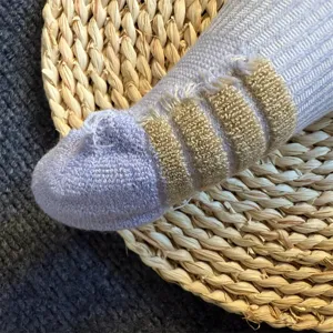 Detail view of women's merino wool striped long socks texture and knit patterns.