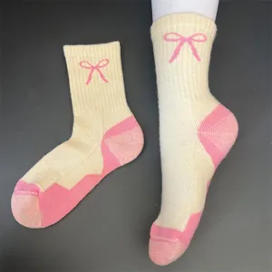Detailed view of women's merino wool thick warm mid-tube socks with cute pink bow and color block