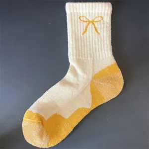 Merino wool mid-calf socks for women featuring a cozy thermal terry design with a cute yellow bow.