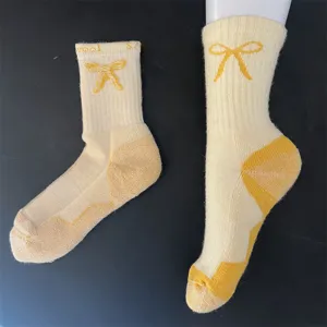 Merino wool mid-calf socks for women, thick thermal terry knit with cute bow and color block.