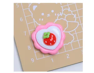 Vista dettagliata del grazioso cabochon in resina a forma di fragola e cuore per fai da te.