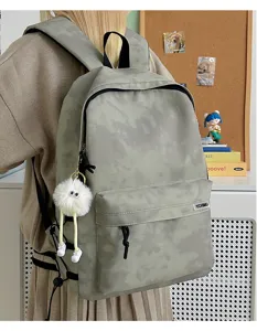 Grey tie-dye college backpack detail view, large capacity casual daypack with fluffy monster charm.