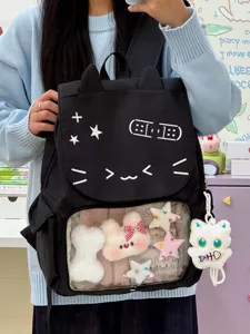 Dettaglio zaino ita gatto nero con tasca frontale trasparente e peluche decorativi.