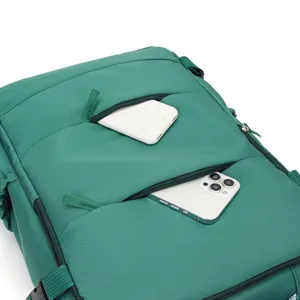 Close-up detail of the green backpack featuring multiple front zipper pockets and durable fabric.