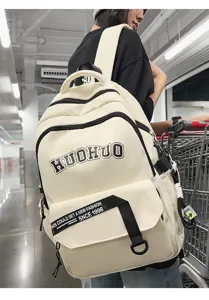 Detail view of a retro style beige backpack with black borders and front slogan strap.
