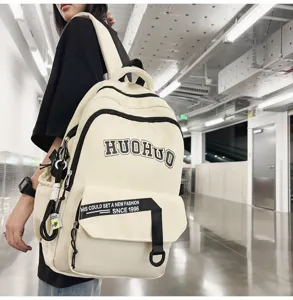 Detail view of stylish casual backpack with letter print and straps in bright corridor setting.