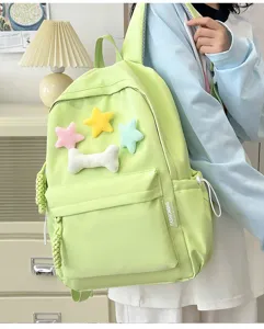 Detail view of a pastel green student backpack with cute plush stars and bone charm.