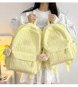 Casual lightweight solid color student backpack with cute bear pendant for daily travel use.