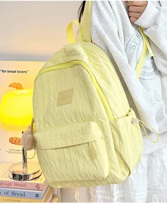 Detail shot of the light yellow casual backpack featuring pleated fabric and compact storage.