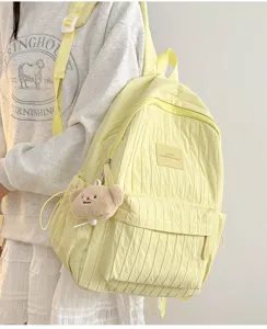 Light yellow wrinkled casual backpack for women, cute daily school bag with bear pendant.