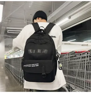 Detailed view of a black college style canvas backpack with multi pockets in a store scene.