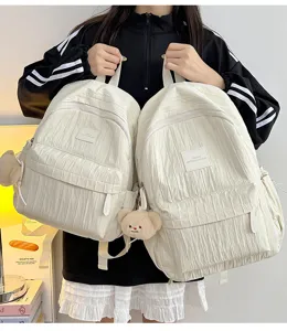 Detailed view of lightweight solid color casual backpack with cute bear pendant and strap.