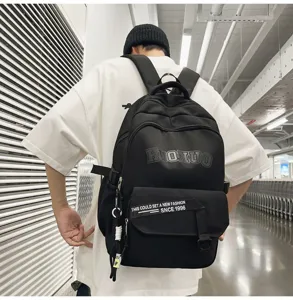 Detail shot of black campus style backpack featuring bold letter print and spacious front pocket.