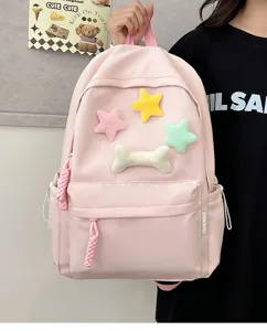 Pink student backpack detail view featuring cute plush star and bone decorations with side pockets.
