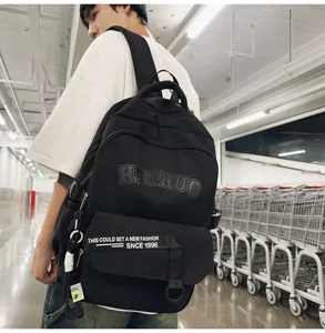 Detailed view of the casual black backpack worn by the model, highlighting straps and pockets.