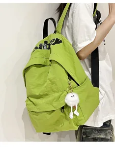 Vista dettagliata dello zaino scolastico verde casual con spallacci neri e morbido ciondolo.